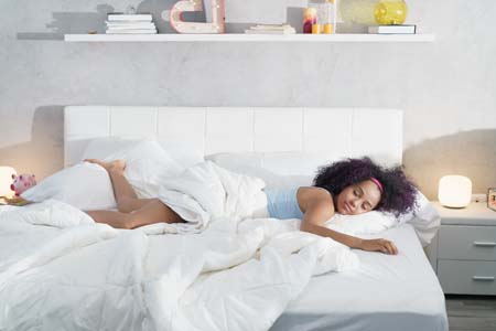 woman sleeping in large bed